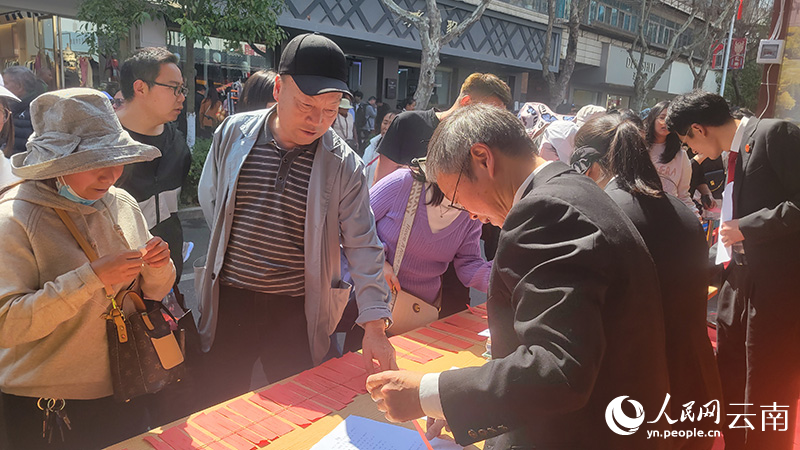 在通海迎春花街，法院的普法摊位前挤满了群众。李雪梅摄