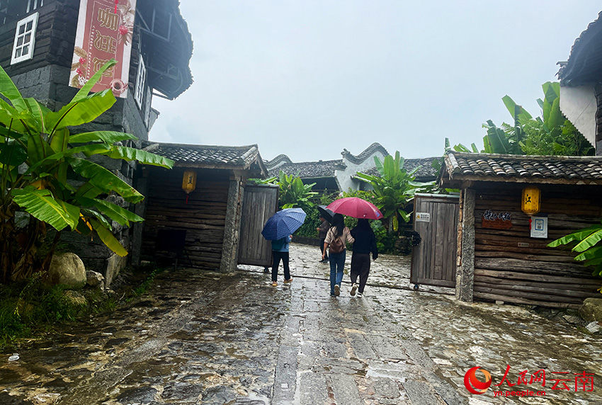 游客雨中游览江苴古镇。人民网记者-程浩摄