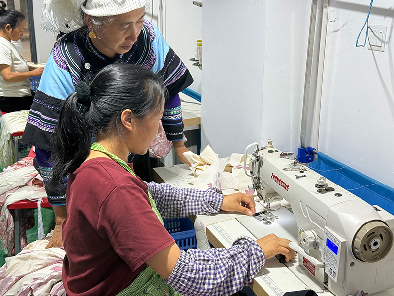缝纫师傅李塘龙努正在为女工示范操作