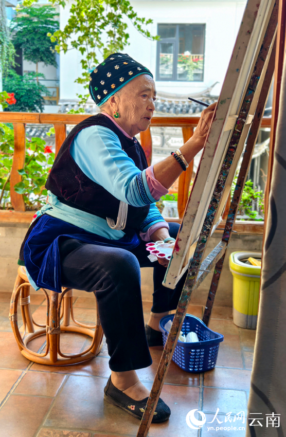 王秉秀正在画画。人民网记者 符皓摄