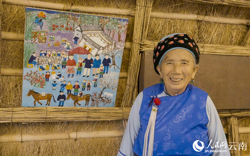 张畅应和她的画，画中画的是她结婚时的场景。人民网记者 符皓摄