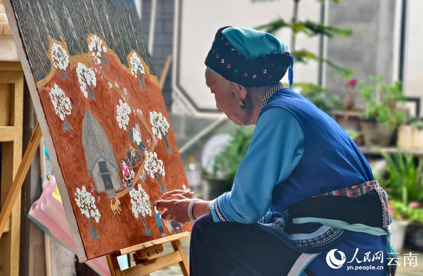李自旺正在画画，画中颜料都是各色泥土。人民网记者 符皓摄