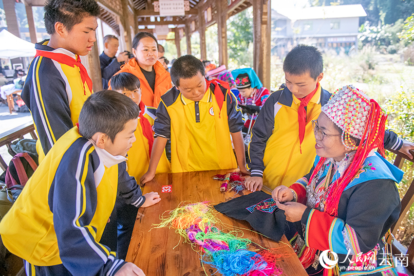 绣娘向学生介绍刺绣。熊平祥摄