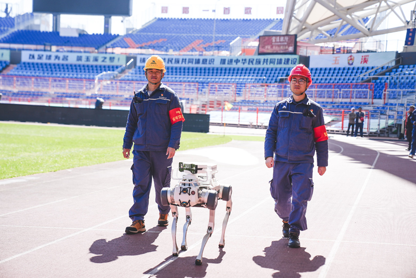 玉溪红塔供电局工作人员带领“吠云”机器狗对滇超联赛赛场进行巡视。方宇摄