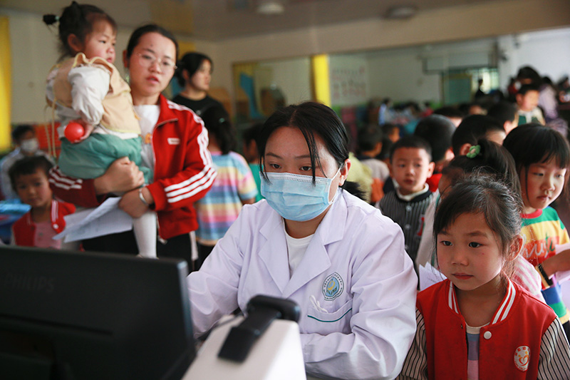 医护人员为儿童开展健康检查。