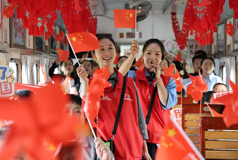 开远米轨观光小火车车厢内，志愿者为乘客讲述滇越铁路历史。云南省委社会工作部供图