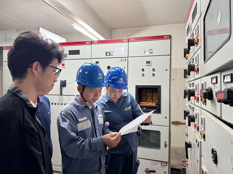 芒市供電局在芒市祥城花園小區配電房和物業溝通電力設施移交情況。段汪寧攝