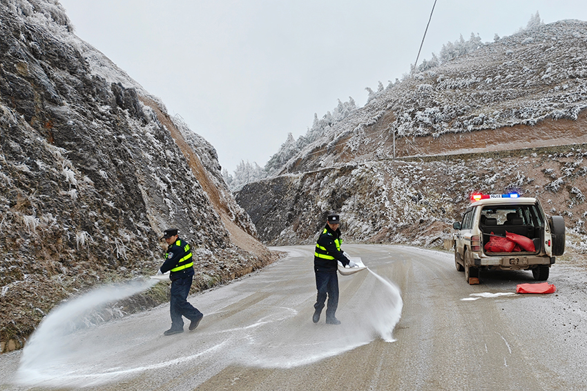 民辅警在冰凌道路抛撒融雪剂。永善警方供图