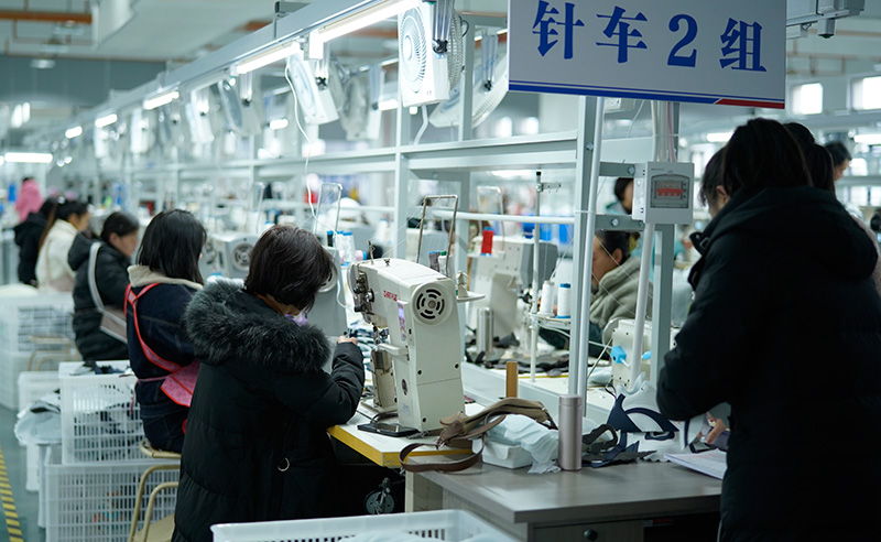 镇雄呢噜坪纺织服装产业园内，云南龙升誉成体育用品公司针车生产车间工人正在缝制鞋面，拍摄于11月20日