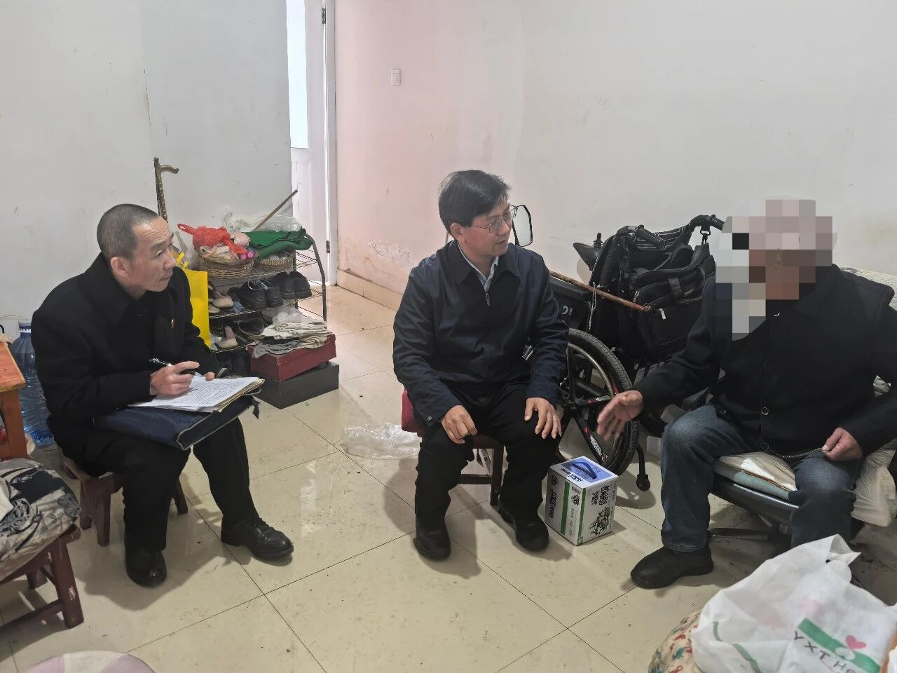 为照顾行动不方便的当事人，晋宁区人民法院院长朱耀元(中)到当事人家中进行接访。