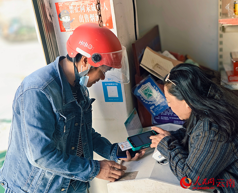 【2】王建梅帮村民缴医保费用。人民网-尹馨摄