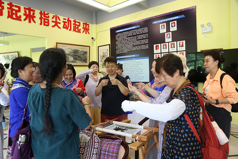 游客体验刺绣中的劈丝技艺。