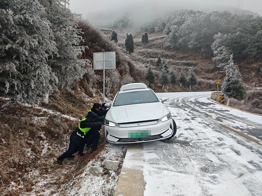 會澤縣公安局大海派出所民警合力救助被困車輛。曲靖市公安局供圖