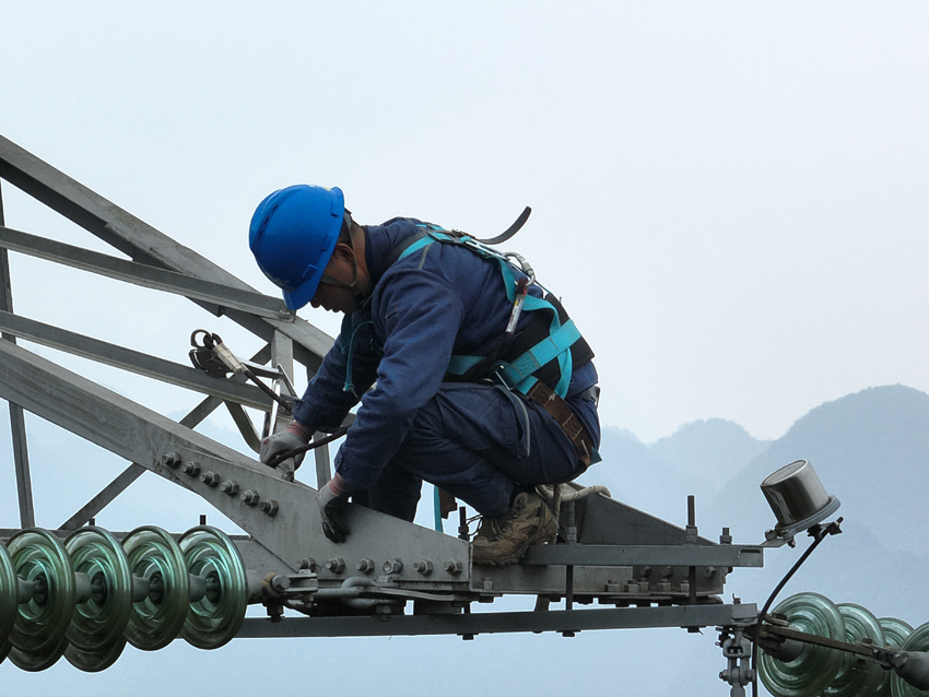 1月7日,曲靖供電局輸電管理所組織專業人員對輸電線路開展消缺作業,圖為作業人員在寒風中登上杆塔開展作業。趙浩益攝