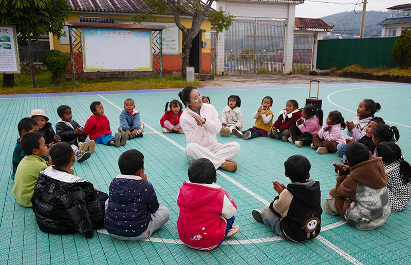 李新月正和孩子們做游戲。陳龍汝男攝