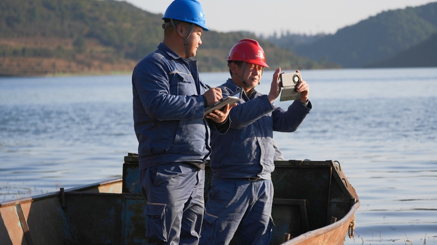 1月13日,曲靖富源供电局墨红供电所工作人员乘船对10千伏玉麦线进行线路巡视。阮松萍摄