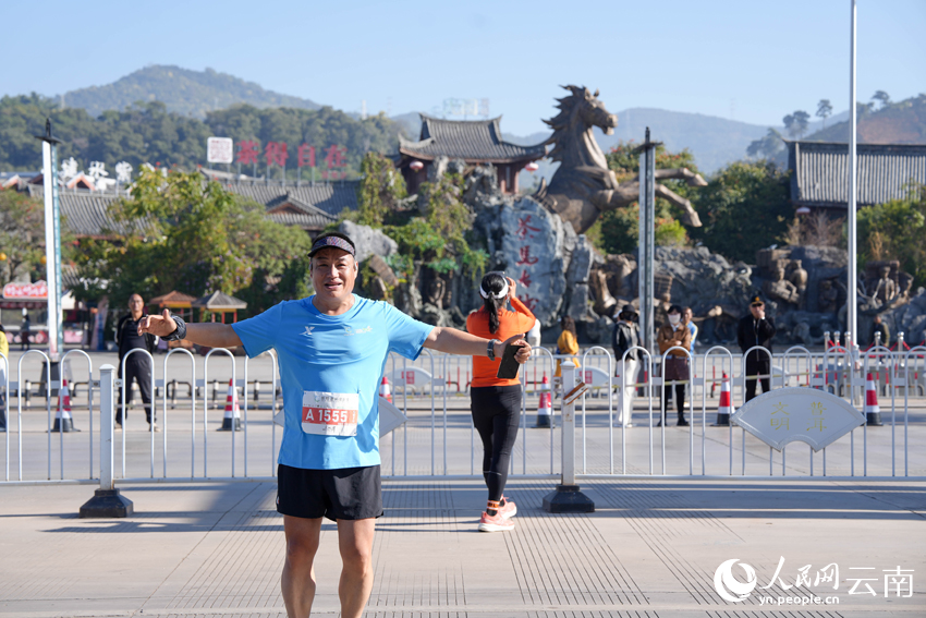 2026普洱思茅馬拉鬆跑者駐足打卡茶馬古城旅游小鎮。人民網 王嫻攝