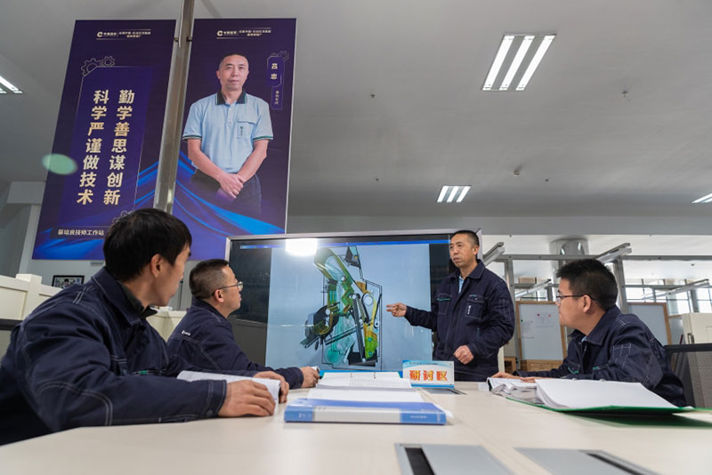 卷包学院里，吕忠正在为年轻修理工们授课。曲靖卷烟厂供图