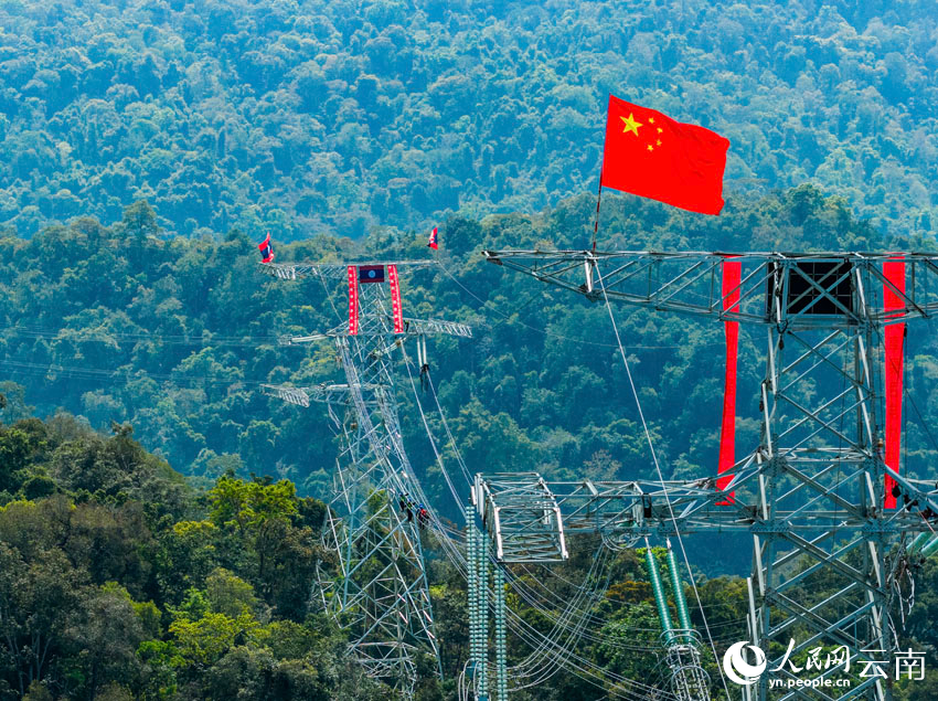 2月5日，施工人员在输电导线跨国连通处作业。任军摄