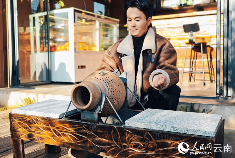 【9】在碗窯村，楊雄飛用土罐烘焙咖啡豆。人民網-尹馨攝