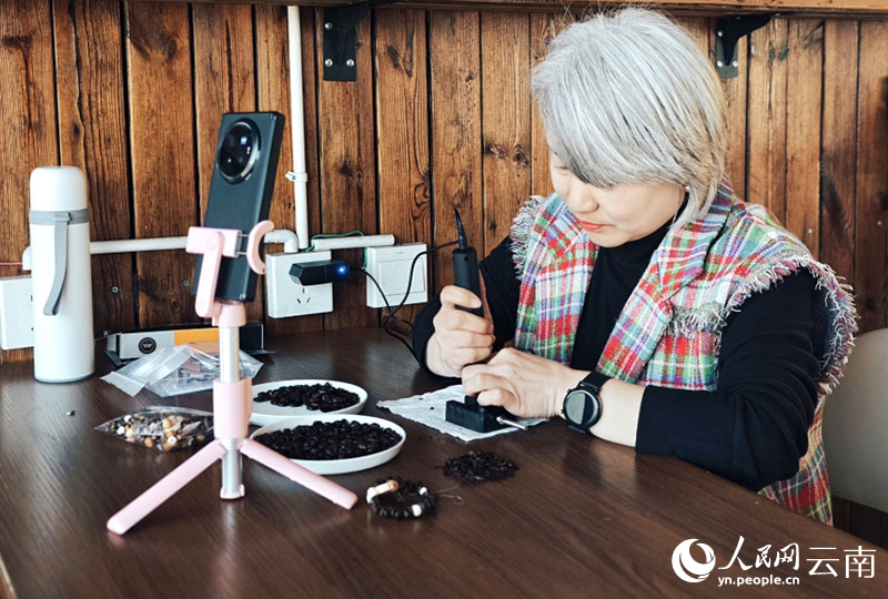 【8】雲佳咖啡庄園裡，工作人員直播用咖啡豆制作手串。人民網-尹馨攝