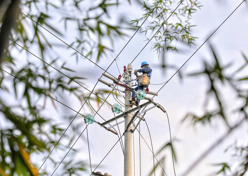 施工人員仔細安裝金具。陳小果攝