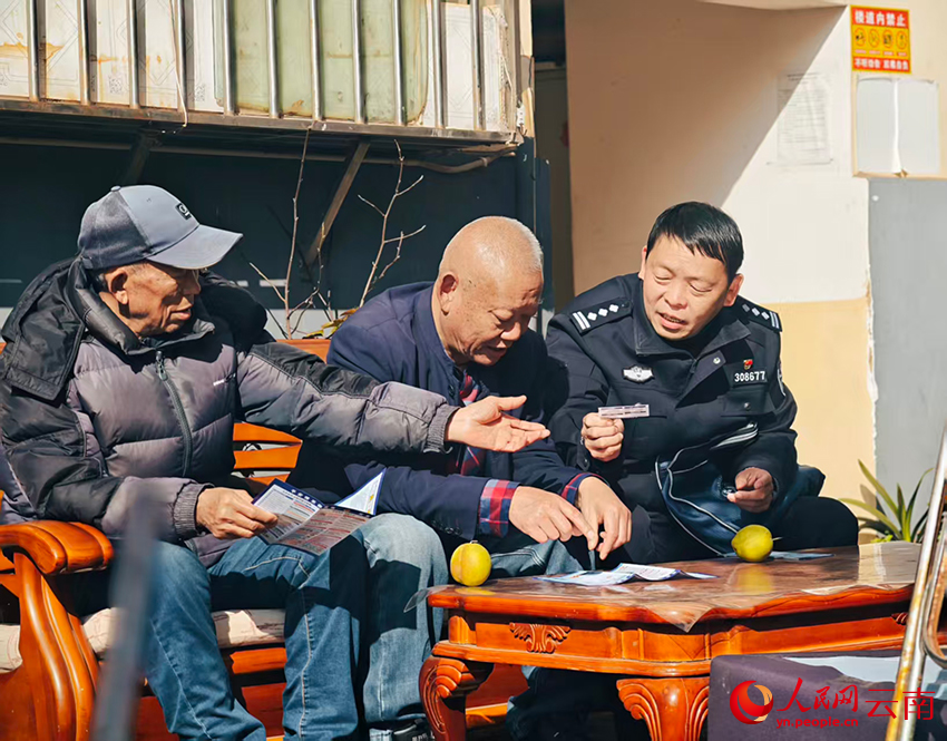【4】社区民警方其林（右一）向居民宣传反诈知识。人民网-尹馨摄