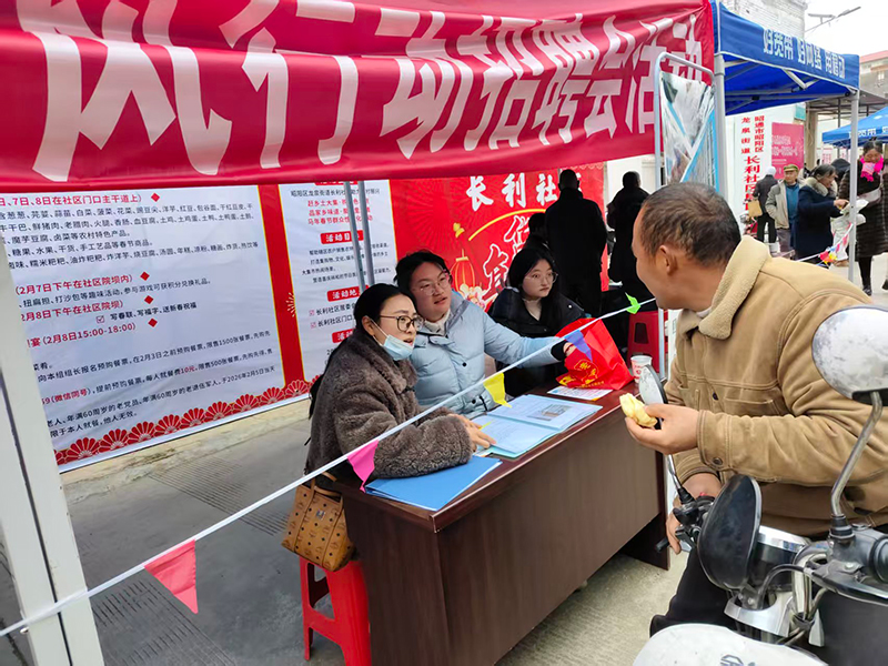 长利社区市集上，返乡人员在“春风行动”招聘会现场咨询岗位信息。王建斌摄。