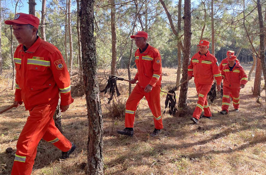 防火队员拿着灭火工具在巡山。段晓宇摄