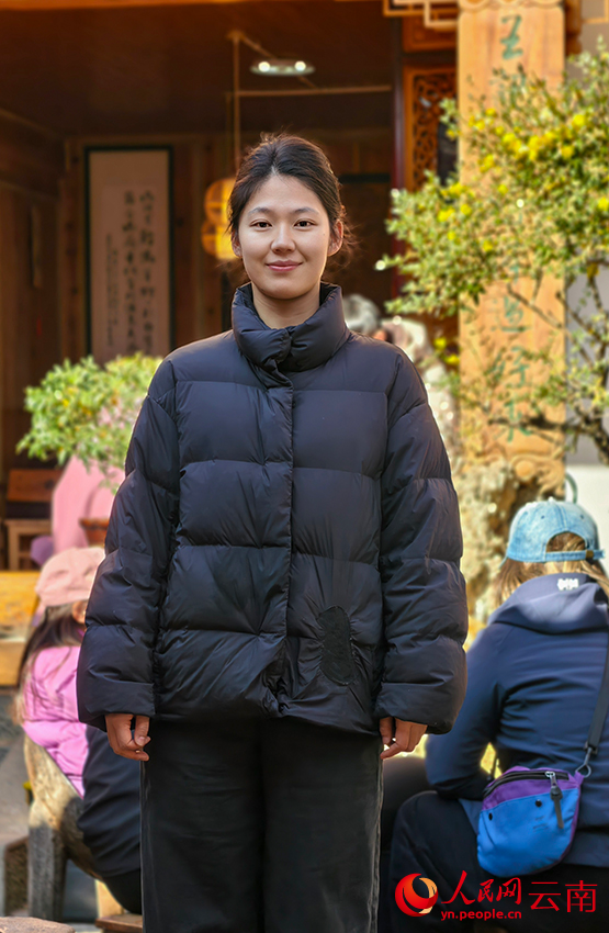 在“王记凉粉”店里的王荔滢,她身后依稀可见挂着的白族语楹联。人民网记者 符皓