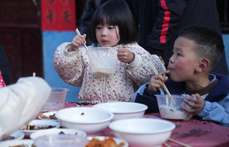 正在品尝美食的小朋友。