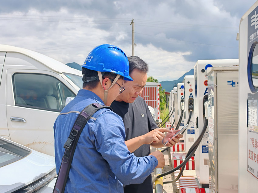 麗江供電局供電服務人員協助充電用戶使用充電設備。田學攝