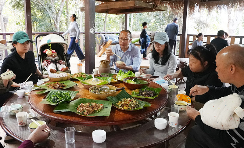 游客品尝佤味美食。艾嘎摄