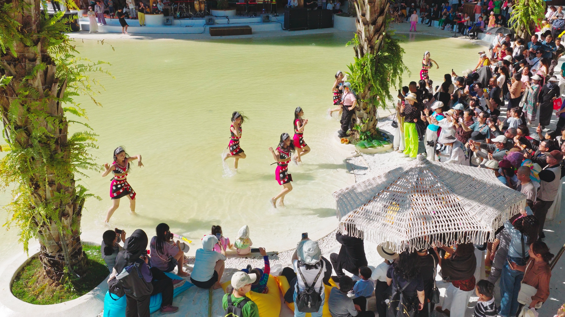 游客在西双版纳州热带花卉园欣赏民族特色表演。