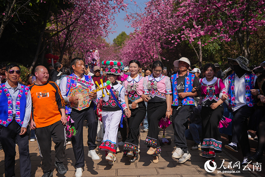 身著民族盛裝的人們在花海中起舞。人民網記者 李發興攝