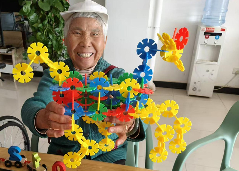 彭奶奶在搭积木。景谷县融媒体中心供图