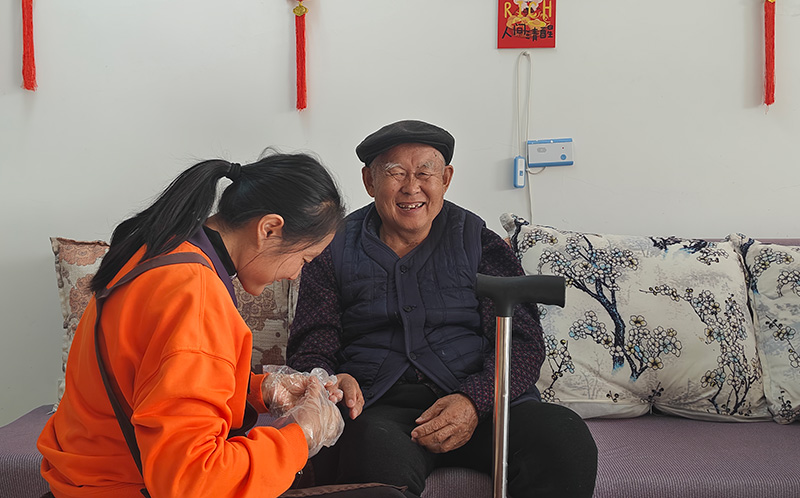 景谷社会福利中心—护理员在给陈爷爷修剪指甲。景谷县融媒体中心供图