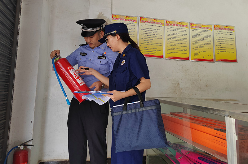 黄增萍与吴清吉正在检查灭火器。