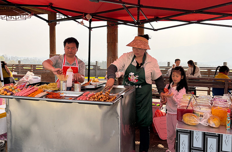 李申科在观景台前的摊位和他的小吃车。杨聪娟摄