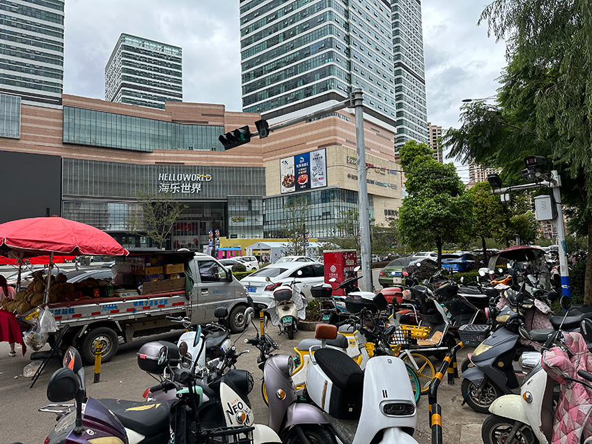 整治前乱摆乱放的非机动车和占道经营的商贩。官渡区委宣传部供图