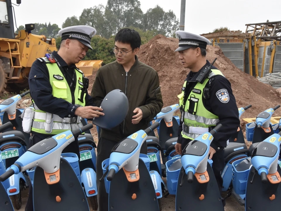 元谋县公安局民警对辖区共享电动车安全头盔进行检查。