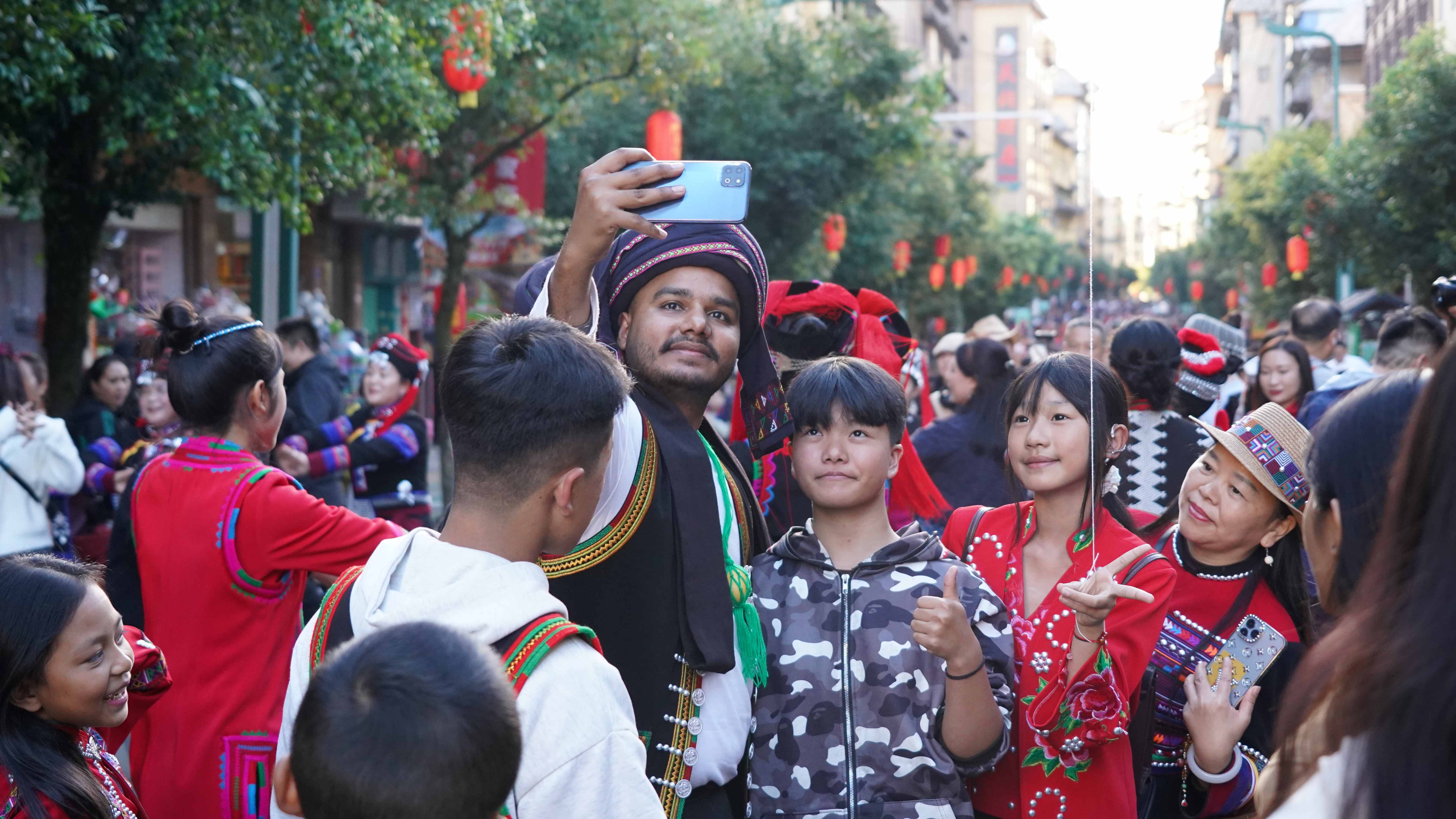 长街宴上外国游客和当地人合影。 黎盟 摄