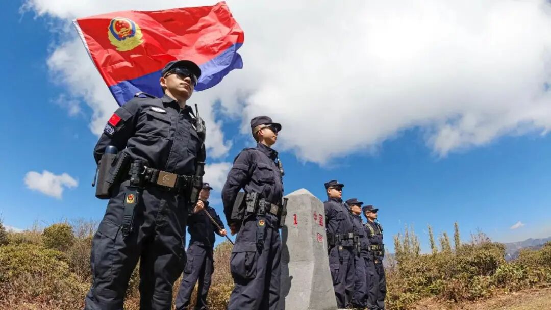 云南边检总站民警在“共和国1号界碑”旁与警旗同框。资料图