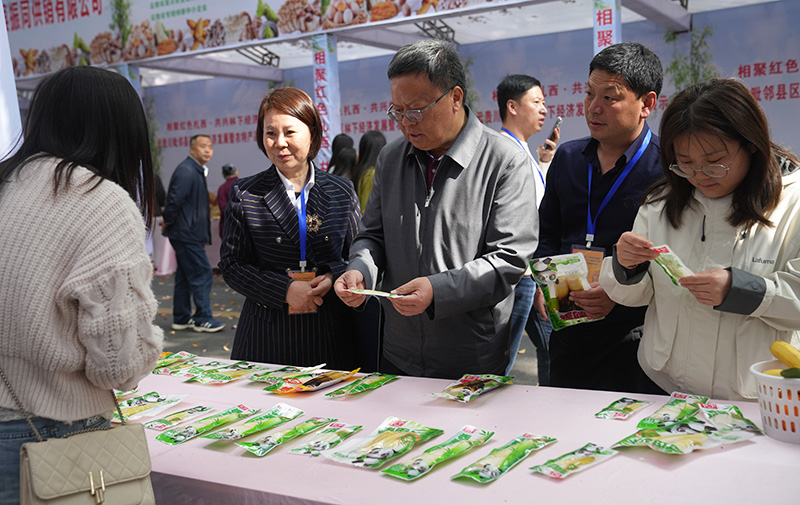 2026年4月12日摄，与会嘉宾参观农特产品展示区