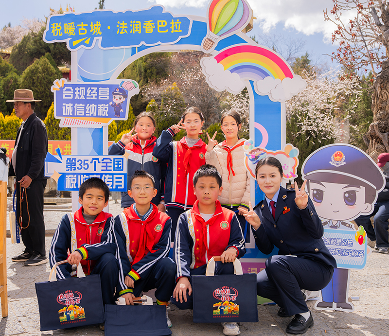 在独克宗古城，税务干部通过摆放税法知识展板、发放青少年税法读本、设置互动咨询台等方式，吸引学生认识了解税法知识。（吴世杰-摄）