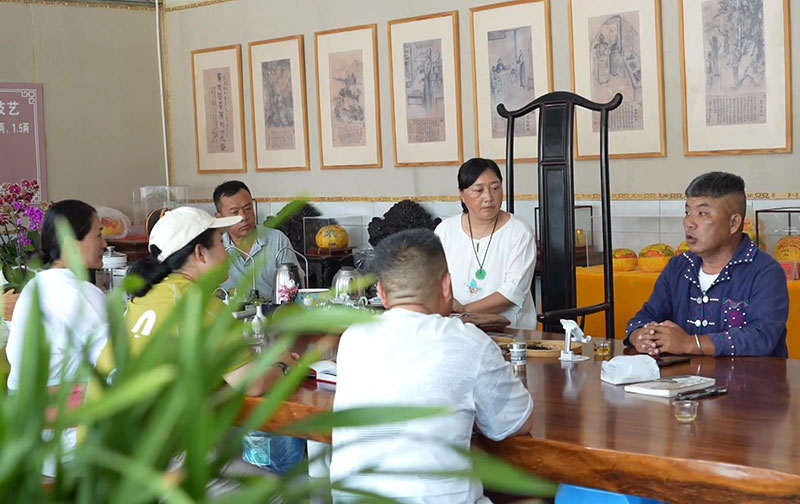 方财兵（右）向茶客讲述民族团结誓词碑相关历史文化。周维艳摄-(1)