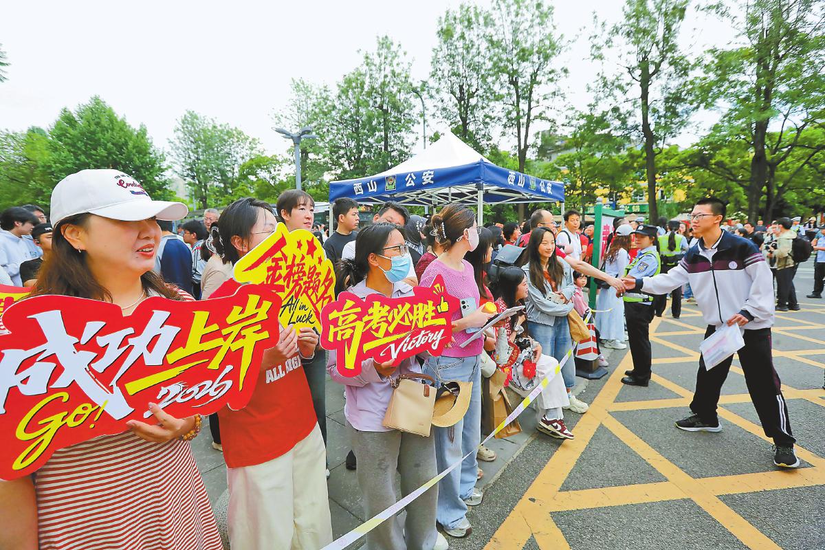 在昆五中考点外，送考老师为考生加油。