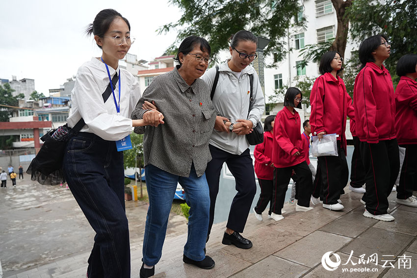 6月8日，张桂梅在同事的搀扶下，陪同考生前往休息区。人民网记者 李发兴摄