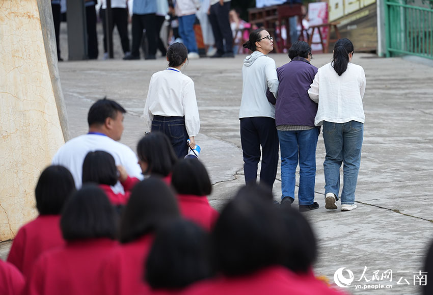6月9日，张桂梅在同事的搀扶下带领考生前往考场。人民网记者 李发兴摄