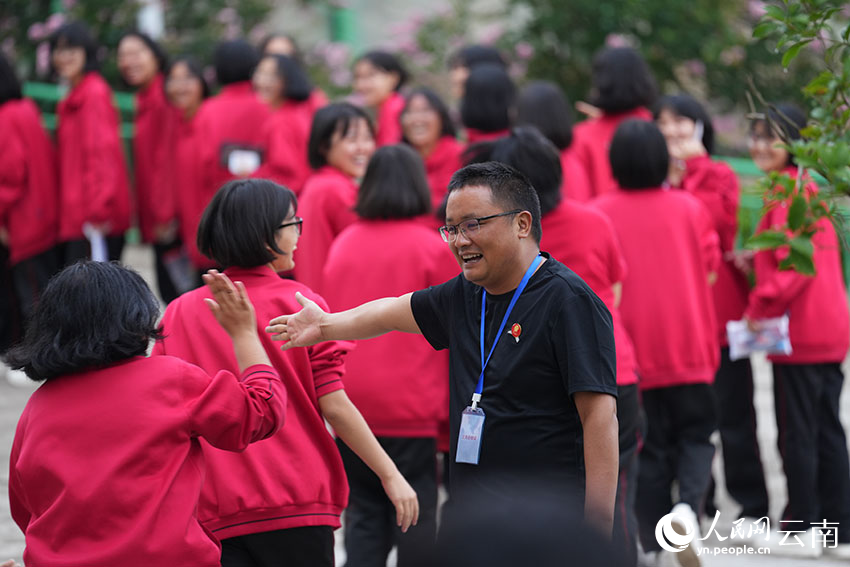 6月9日，进入考场前，老师与学生与每一位即将入场的学生击掌、碰拳，为他们加油助威。人民网记者 李发兴摄